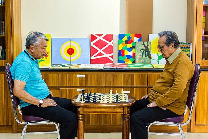 Dua senior bermain catur untuk melatih fokus dan daya ingat