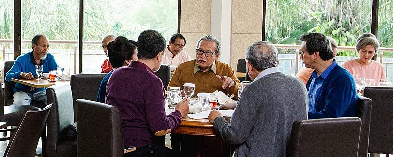 Para senior menikmati makan dan berbincang bersama