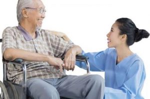 perawat yang sedang berkomunikasi dengan lansia